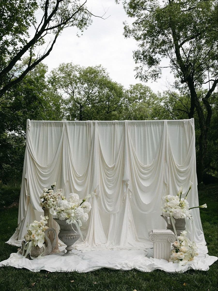 Sección de fotos — Composición floral sobre telón drapeado